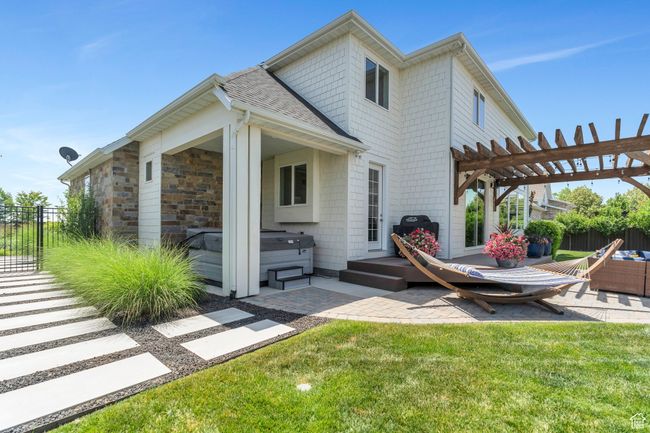 Rear view of property with a hot tub, a patio, a pergola, and roof with shingles | Image 74