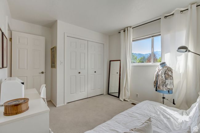 Bedroom with light colored carpet, baseboards, a mountain view, and a closet | Image 23