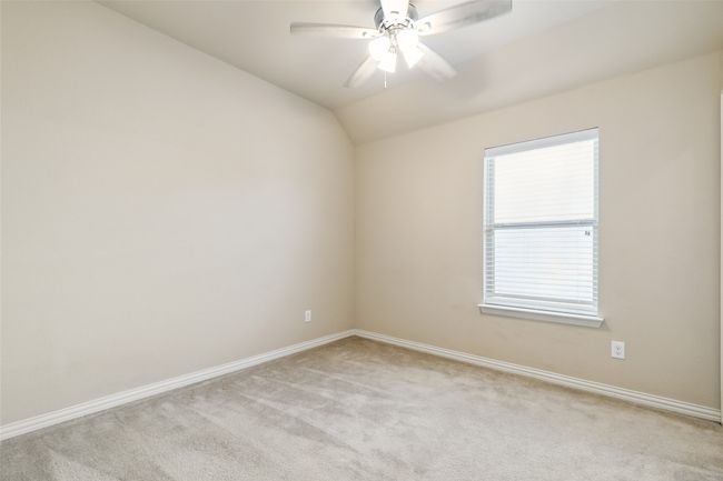 Spare room with light carpet, baseboards, lofted ceiling, and a ceiling fan | Image 31