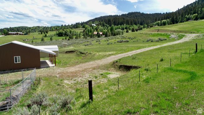 View of mountain backdrop featuring rural landscape and a forest | Image 12