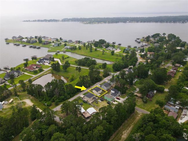 View of green space, one of two ponds in front of the home, and big water from aerial photography. | Image 37