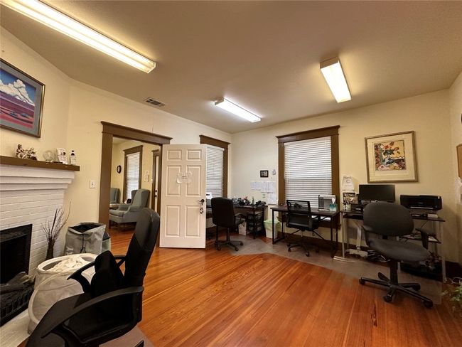 Home office with wood finished floors and a fireplace | Image 12