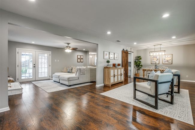 Living area featuring a barn door, french doors, recessed lighting, wood finished floors, and a ceiling fan | Image 4