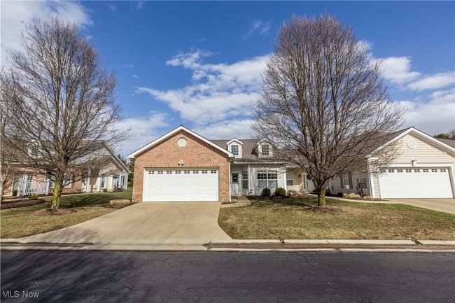 View of front of home featuring driveway, a garage, a front lawn, and brick siding | Image 29