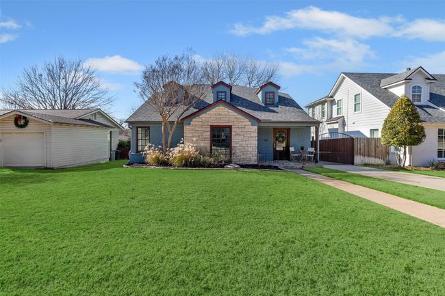 View of front of house featuring a porch, a front lawn, a garage, and an outbuilding | Image 27