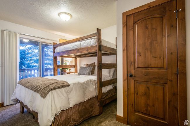 Carpeted bedroom featuring access to outside and a textured ceiling | Image 9