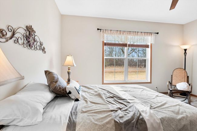 Bright and airy with a modern ceiling fan and natural light pouring in through the large window. | Image 25