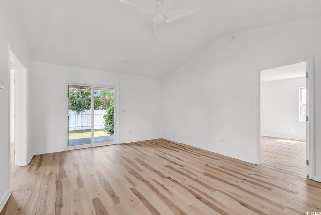Spare room featuring ceiling fan, vaulted ceiling, and light wood-style floors | Image 10