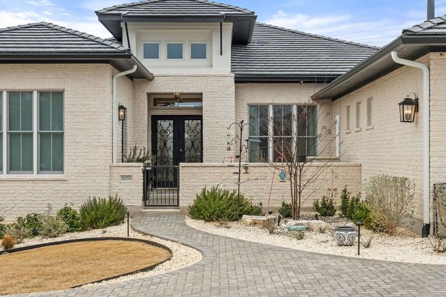 Entrance to property featuring a gate, brick siding, and a tiled roof | Image 4