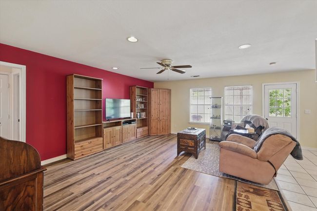 Living room with light wood-style flooring, baseboards, a ceiling fan, and recessed lighting | Image 9