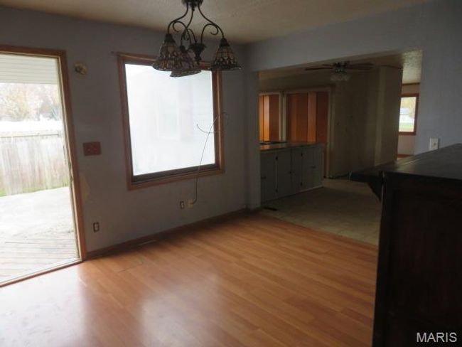 Unfurnished dining area with ceiling fan with notable chandelier and light wood-type flooring | Image 19