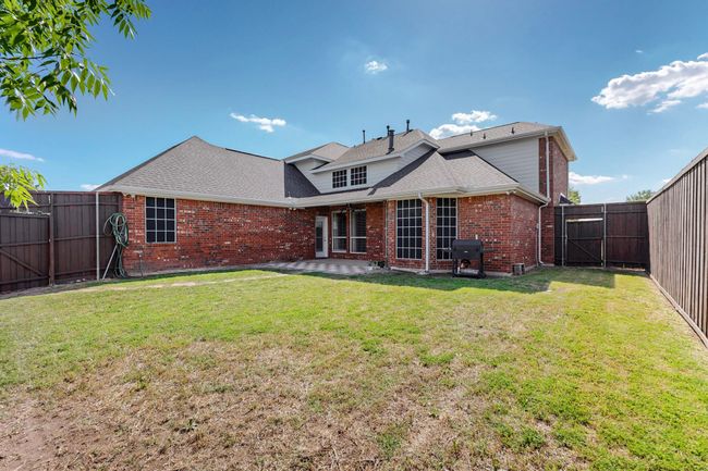 Rear view of property with brick siding, a patio area, a lawn, and a fenced backyard | Image 34