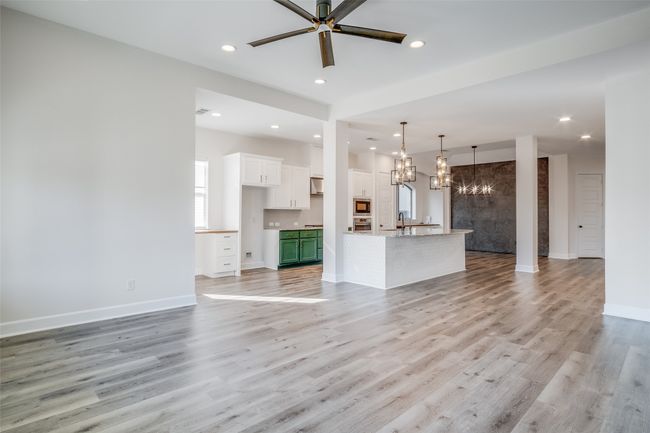 Unfurnished living room with a chandelier, light wood-style flooring, ceiling fan, and recessed lighting | Image 17