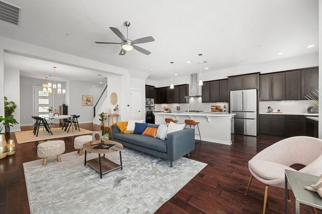 The living room includes high ceilings and engineered hardwood flooring, creating a sense of openness and a sophisticated flow that connects effortlessly to the dining and kitchen | Image 9