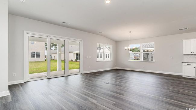 Unfurnished living room featuring lofted ceiling, a notable chandelier, and dark hardwood / wood-style flooring | Image 20