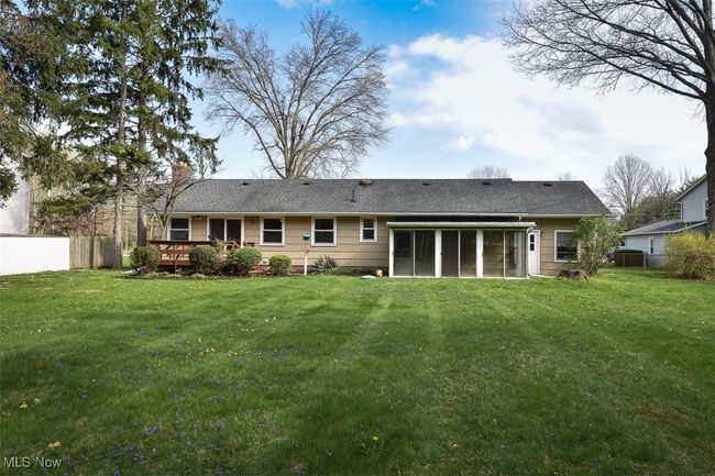 Rear view of property featuring a yard, a sunroom, fence, and a deck | Image 6