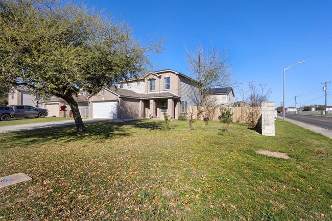 View of front facade with a garage, a front lawn, concrete driveway, and fence | Image 5
