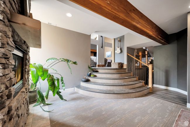 Stairway with baseboards, visible vents, beamed ceiling, and a fireplace | Image 22