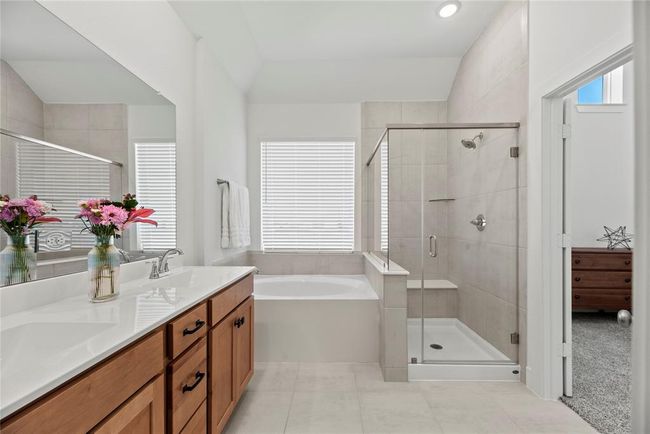 The primary bathroom is complete with a dual sink vanity, soaking tub, separate shower and walk-in closet. | Image 14