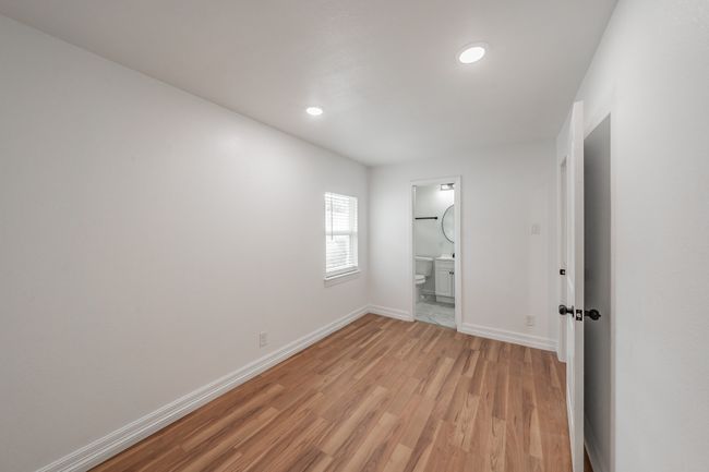 Unfurnished bedroom with light wood-style flooring, baseboards, recessed lighting, and ensuite bath | Image 9