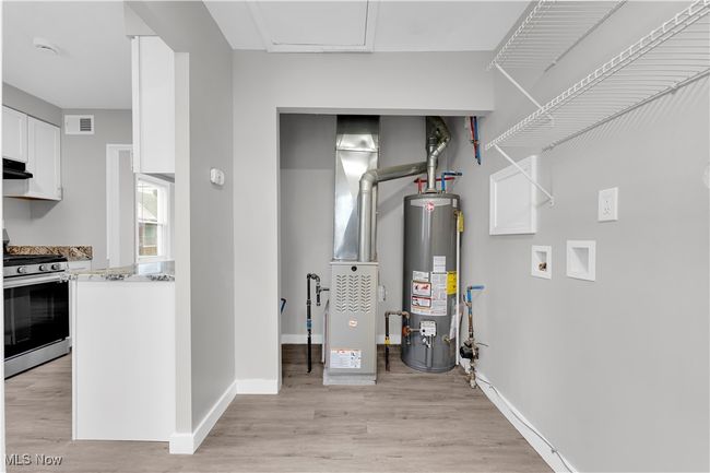 Utility room featuring visible vents and water heater | Image 19