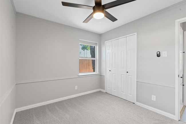 Unfurnished bedroom with carpet flooring, a closet, ornamental molding, and ceiling fan | Image 17