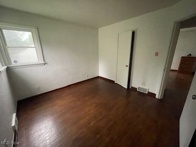 Bedroom with dark wood-type flooring and baseboards | Image 17