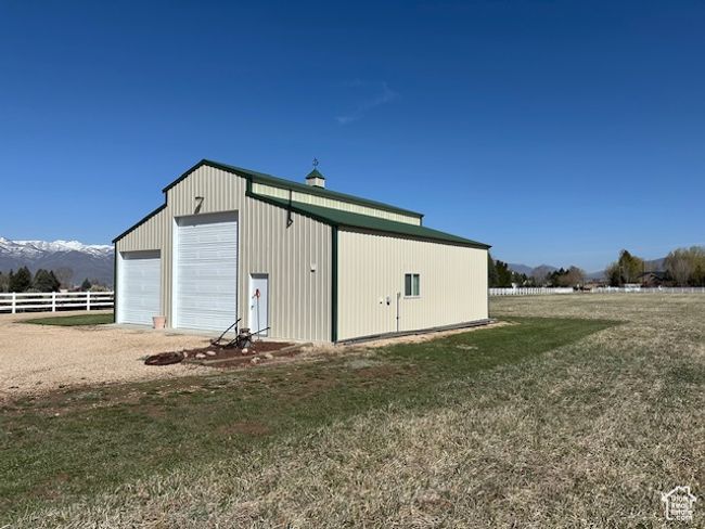 View of outdoor structure featuring an outbuilding, a mountain view, and fence | Image 5