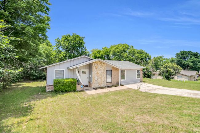View of front of property featuring board and batten siding, concrete driveway, and a front yard | Image 33