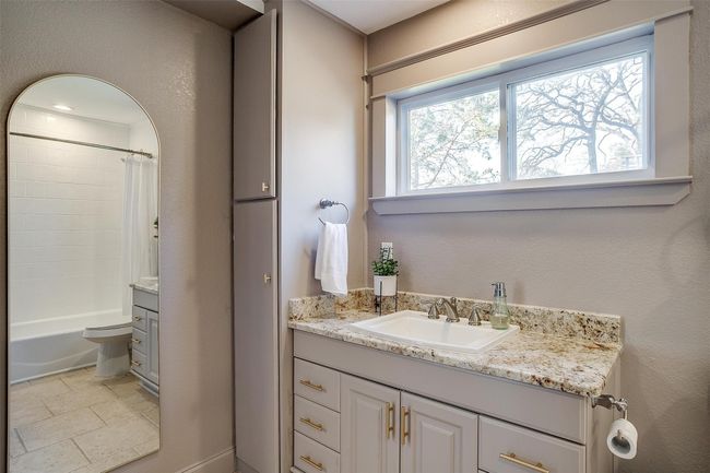 Full bathroom with vanity, shower / bath combination with curtain, and toilet | Image 25