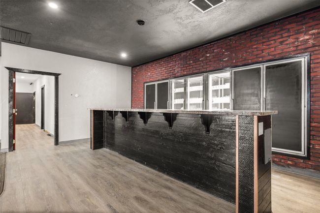 Bar area featuring light wood-type flooring, brick wall, recessed lighting | Image 46