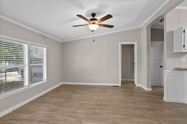 Spare room featuring ceiling fan, crown molding, and light wood finished floors | Image 16