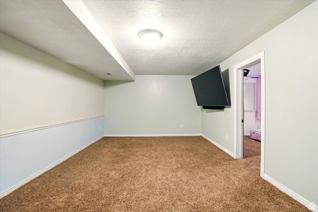 Carpeted spare room featuring a textured ceiling and baseboards | Image 21