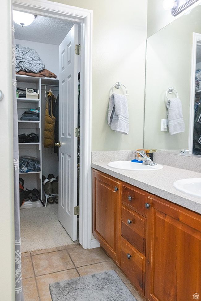 Full bath featuring double vanity, a walk in closet, and tile patterned floors | Image 18