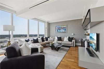 Living room featuring floor to ceiling windows and hardwood / wood-style flooring | Image 2