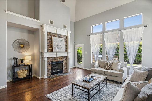 Living room featuring a fireplace, dark hardwood / wood-style flooring, and a towering ceiling | Image 11