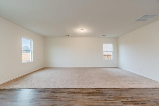 Carpeted spare room featuring baseboards and wood finished floors | Image 13