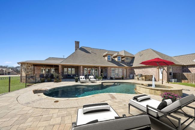 Summer is here! Cool off on Texas summer days in this refreshing Robertson pool with spa and water feature. Generous decking allows for space for lounge chairs and other outdoor furnishings. | Image 32