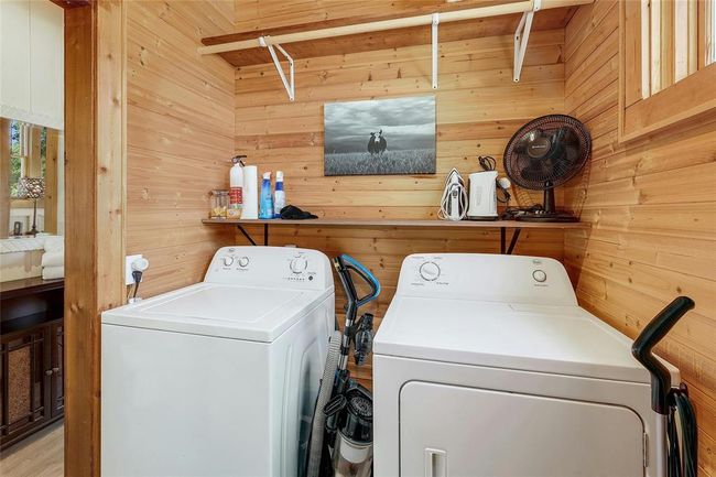 Washroom with washing machine and clothes dryer, wood walls, and laundry area | Image 22