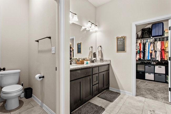 Full bath featuring double vanity, a walk in closet, and tile patterned floors | Image 15