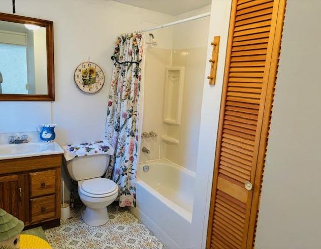 Full bathroom featuring vanity, toilet, and shower / bath combo with shower curtain | Image 15