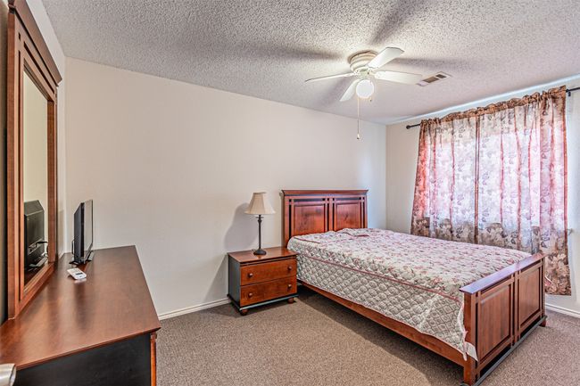 Bedroom featuring light carpet, ceiling fan, and a textured ceiling | Image 21