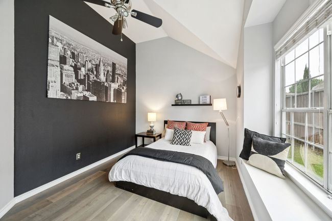 This vaulted bedroom features a striking accent wall and oversized window with built-in bench seating—perfect for reading, relaxing, or just enjoying the view. | Image 23
