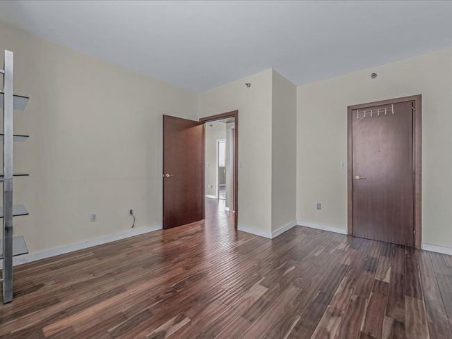 Unfurnished room with dark wood-style floors and baseboards | Image 9
