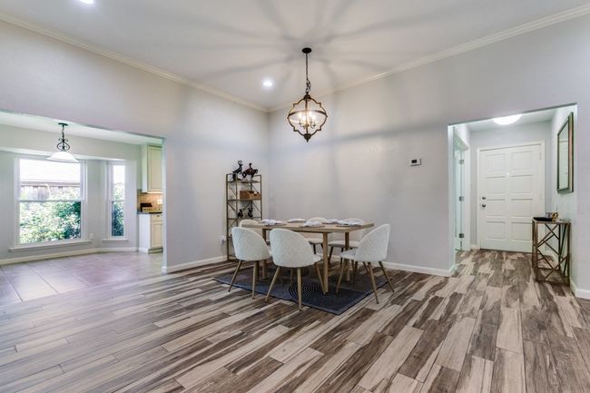 Dining space with wood finished floors, crown molding, a chandelier, and recessed lighting | Image 10