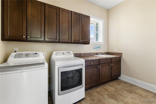 First floor laundry, tile floors, closet, cabinets, laundry sink, 10' ceilings, 8' doors, access to 2 car garage | Image 18