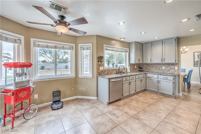 Kitchen gray cabinetry, decorative backsplash, stainless steel dishwasher, and a sink | Image 17