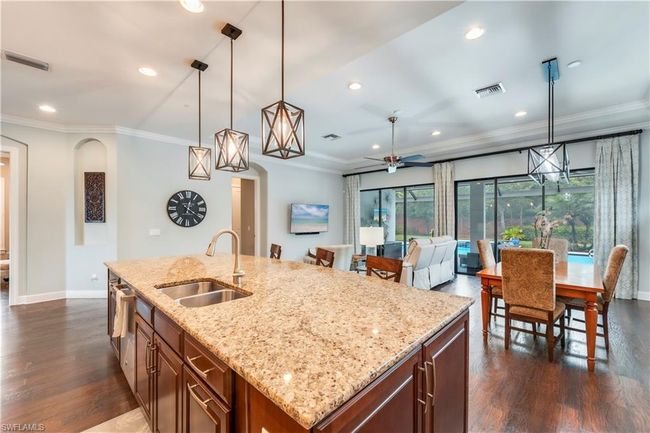 Kitchen with a sink, dark wood-type flooring, crown molding, baseboards, and recessed lighting | Image 9
