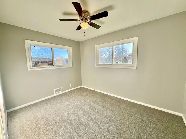 carpeted spare room featuring plenty of natural light, visible vents, and baseboards | Image 19