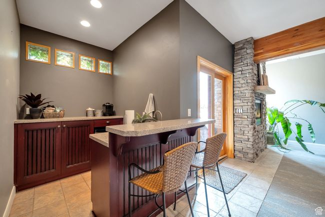 Bar with light tile patterned floors, recessed lighting, a dry bar, and plenty of natural light | Image 26